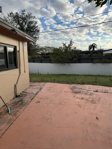 a view of a yard with wooden fence