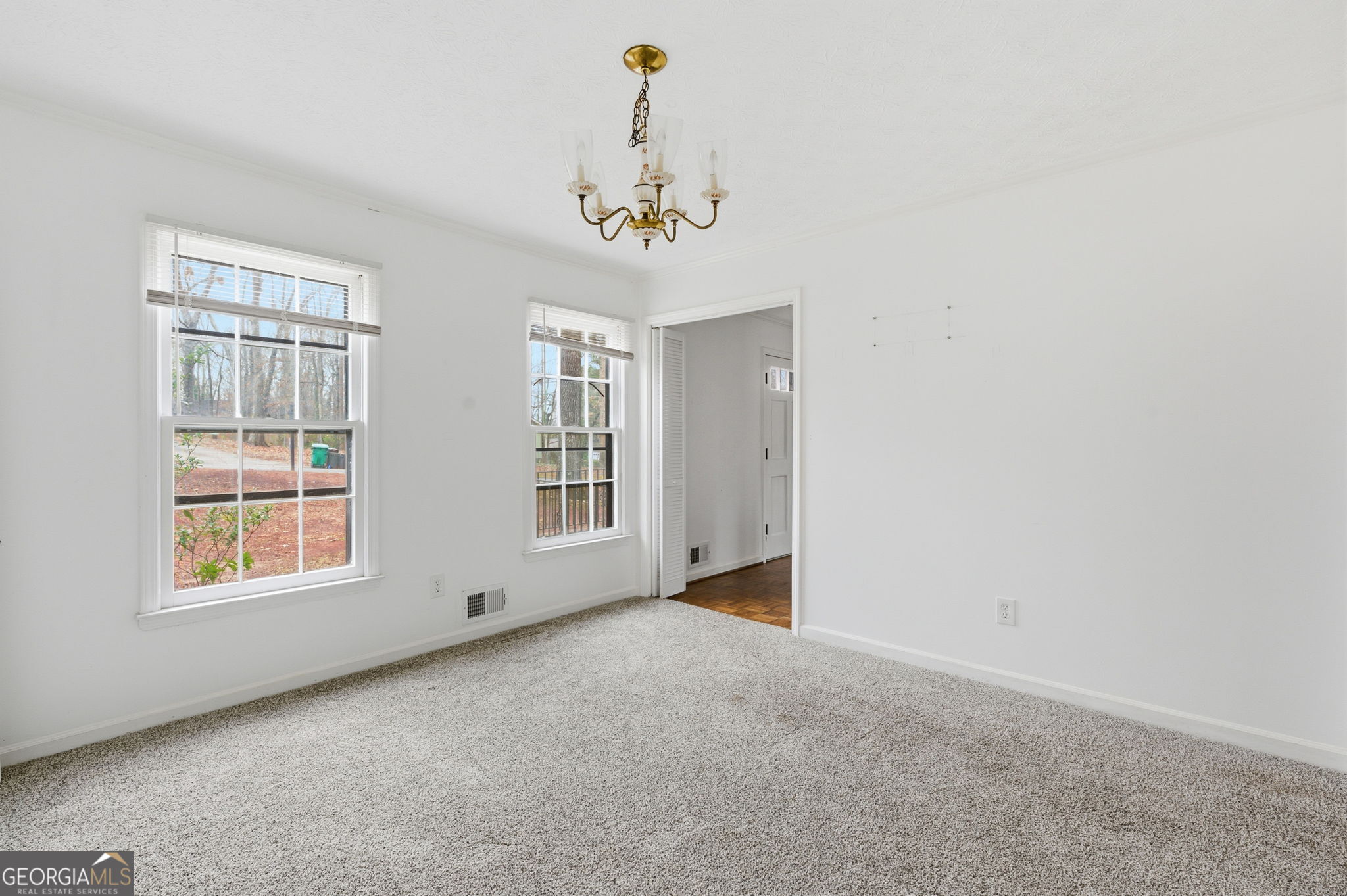 1732 Golfcrest Court Stone Mountain, GA 30088 - Photo 23 of 41 an empty room with windows and chandelier