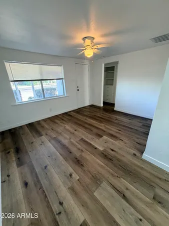 a view of empty room with wooden floor