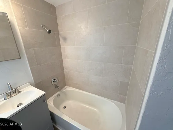 a white bath tub sitting next to a white sink and vanity