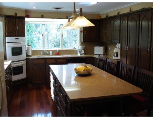 2 Nowers Road Lexington, MA 02420 - Photo 13 of 22 a kitchen with a table chairs a stove and a refrigerator
