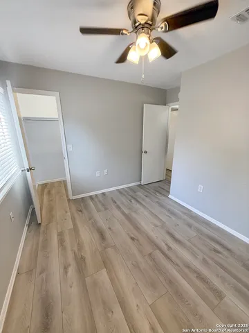 wooden floor in an empty room with a fan
