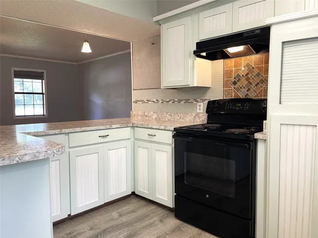 a kitchen with stainless steel appliances granite countertop a sink and a white cabinets