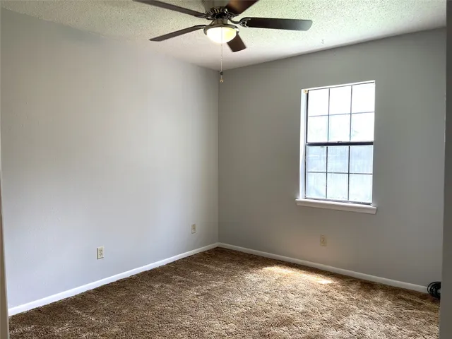 a bathroom with a granite countertop toilet sink and mirror