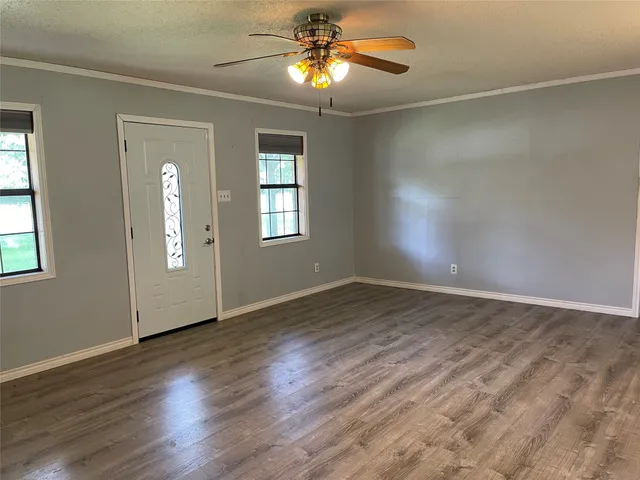 an empty room with wooden floor and windows