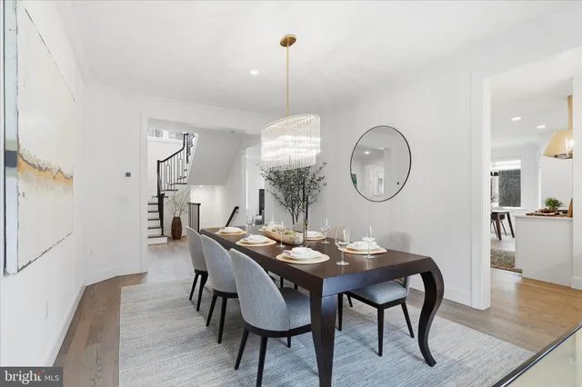 a dining room with furniture a rug and a mirror