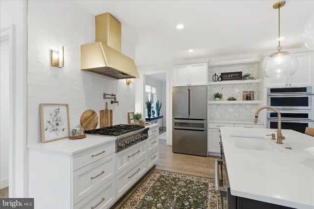 a kitchen with stainless steel appliances granite countertop a sink a stove and a refrigerator