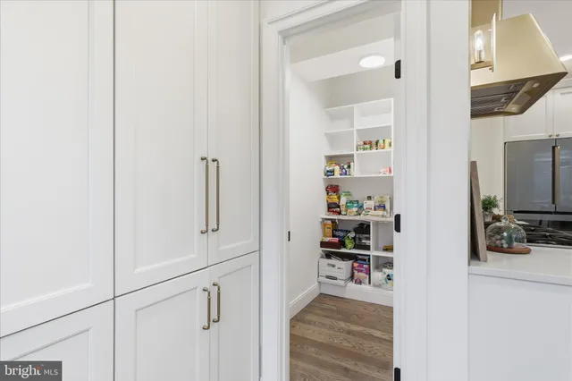 a view of a hallway with wooden floor and closet