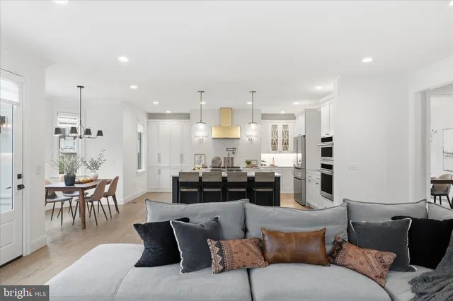 a living room with furniture kitchen area and a table