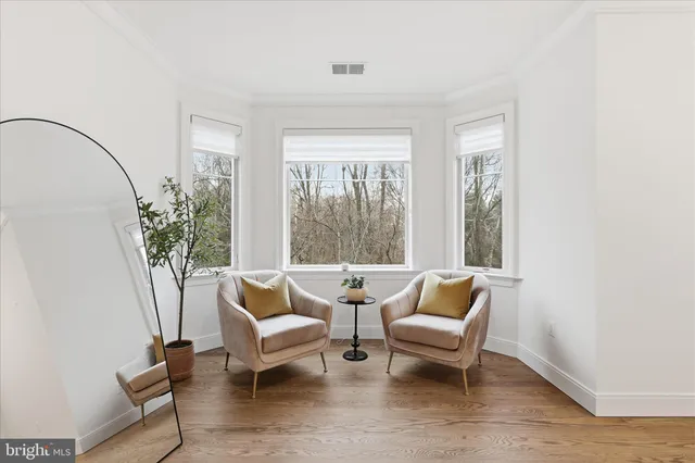 a living room with a bed furniture and a large window