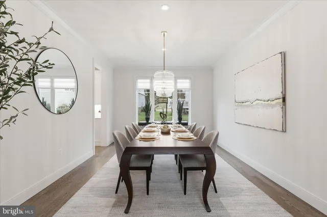 a dining room with wooden floor a chandelier a wooden table and chairs
