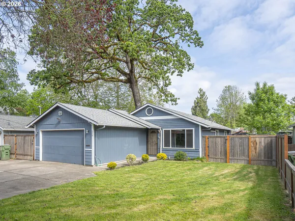 a front view of a house with a yard and trees