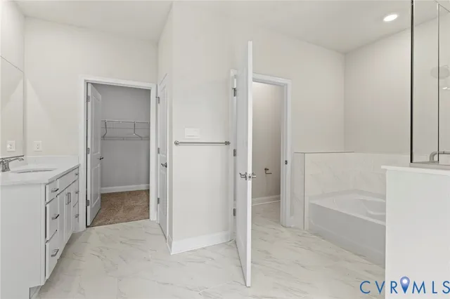 a bathroom with a granite countertop sink a mirror and a bathtub