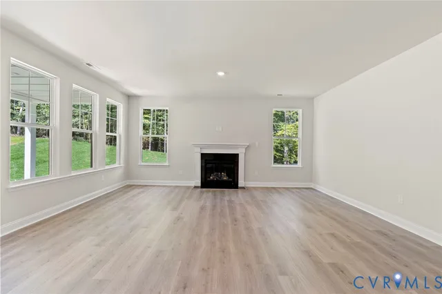an empty room with windows and fireplace