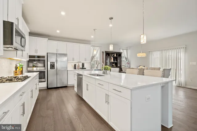 a kitchen with white cabinets appliances and sink