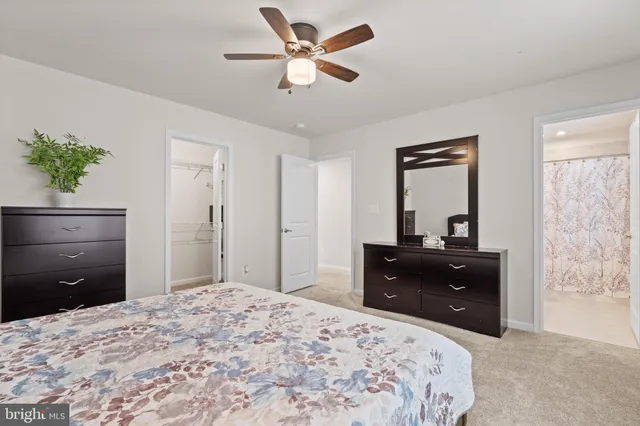 a living room with furniture and a computer on the desk next to a window