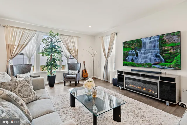a living room with furniture a window and a flat screen tv