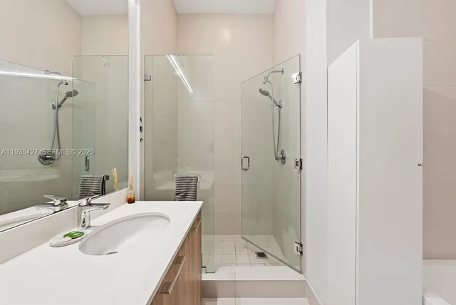 a bathroom with a sink shower and a mirror