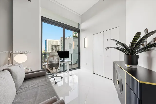 a living room with furniture a flat screen tv and a floor to ceiling window