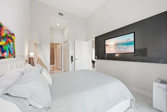 a bedroom with a bed and a painting on the wall