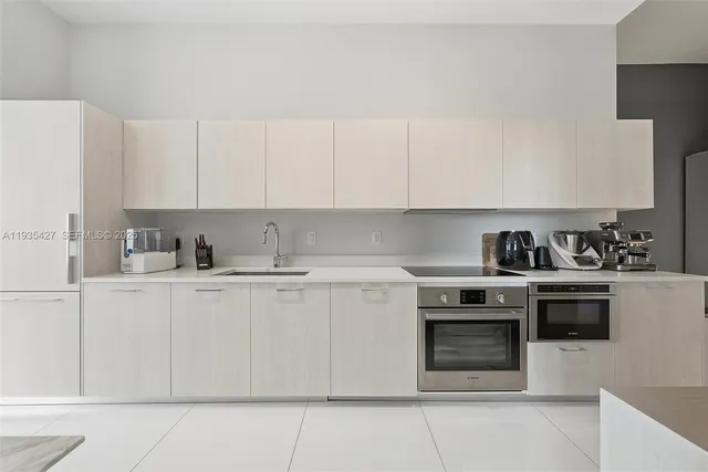 a kitchen with stainless steel appliances granite countertop a stove a sink and white cabinets