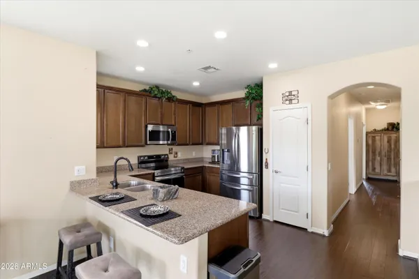 a kitchen with stainless steel appliances granite countertop a sink stove and refrigerator