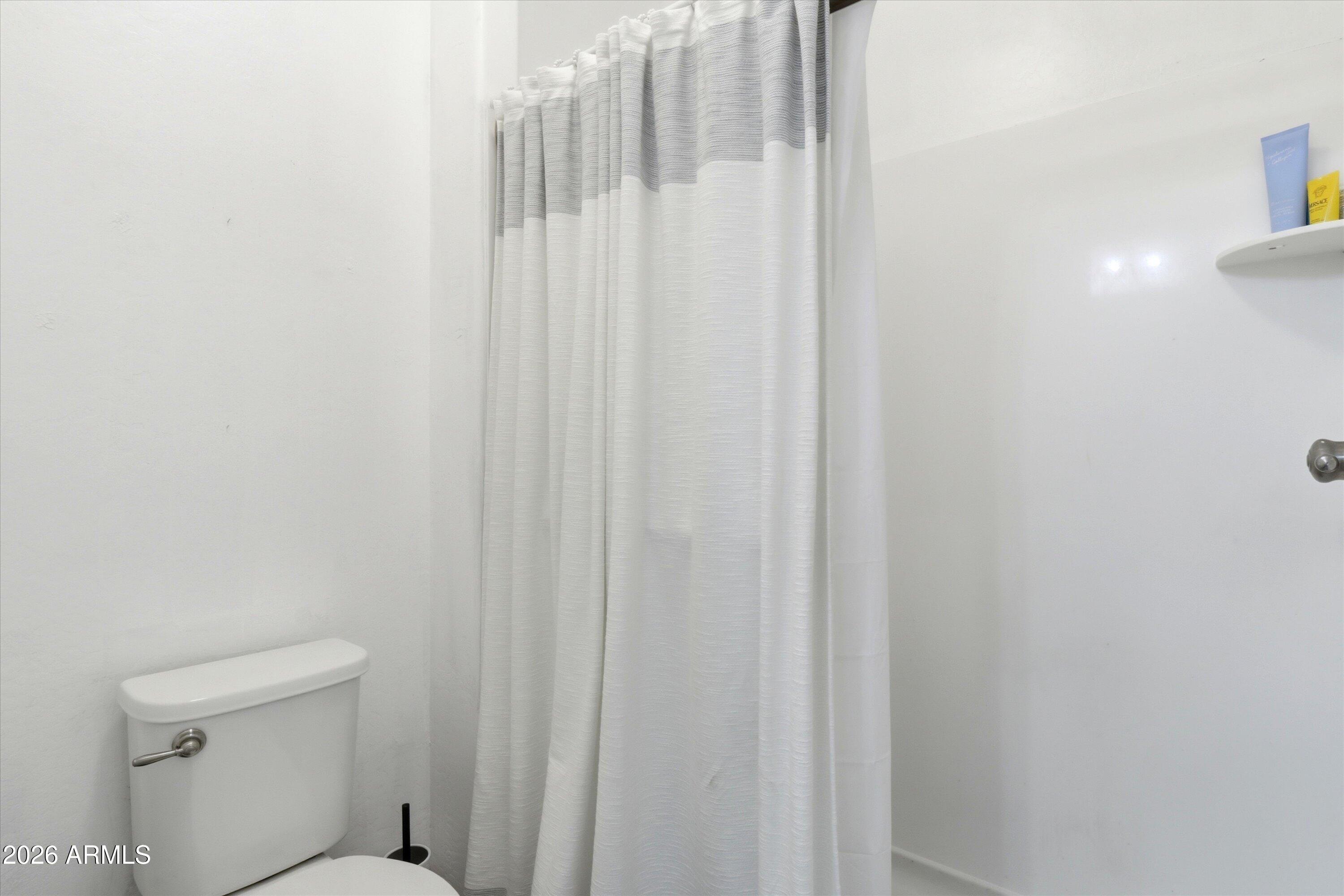 7726 East Baseline Road, Unit 227 Mesa, AZ 85209 - Photo 21 of 22 a bathroom with a shower curtain