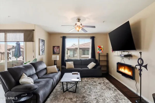a living room with furniture a flat screen tv and a fireplace