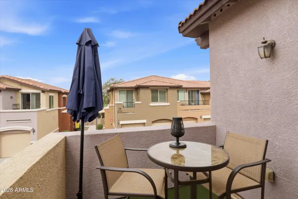 a balcony with table and chairs