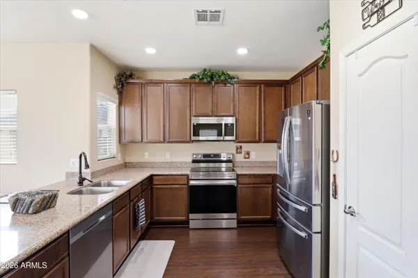 a kitchen with stainless steel appliances granite countertop a refrigerator stove microwave and sink