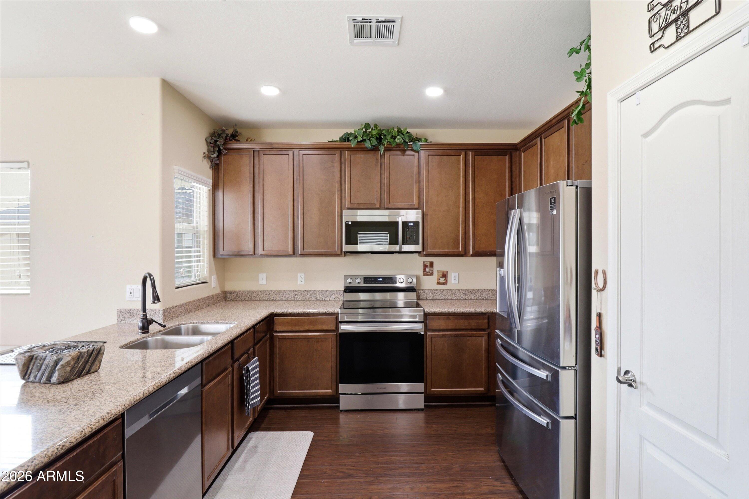7726 East Baseline Road, Unit 227 Mesa, AZ 85209 - Photo 10 of 22 a kitchen with stainless steel appliances granite countertop a refrigerator stove microwave and sink