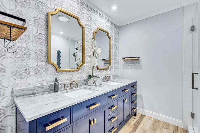 a bathroom with a granite countertop double vanity sink and a mirror
