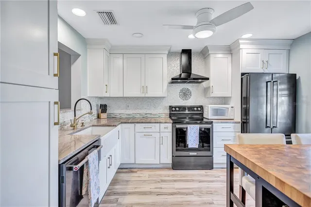 a kitchen with stainless steel appliances granite countertop a stove sink and refrigerator