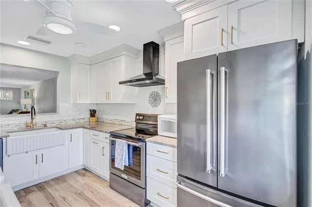 a kitchen with stainless steel appliances a refrigerator sink and cabinets