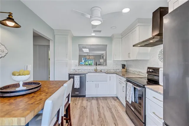 a kitchen with a sink a stove cabinets and a dining table