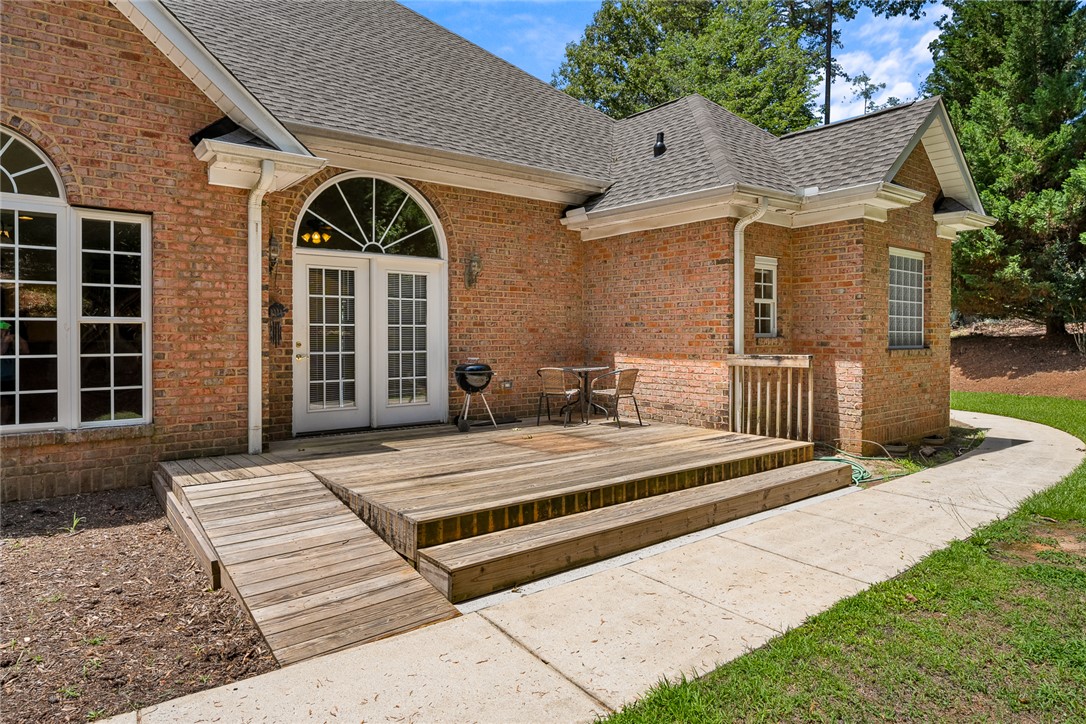 135 Sunset Bay Boulevard Seneca, SC 29672 - Photo 42 of 50 A spacious wooden deck with a ramp extends from this classic brick home, perfect for outdoor relaxation.