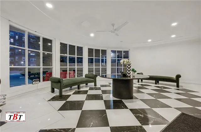 a living room with a black white checkered floor with couches chair and a coffee table
