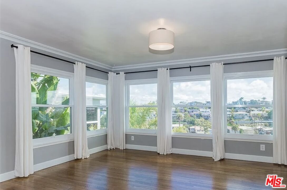 7032 Trask Avenue Playa del Rey, CA 90293 - Photo 6 of 35 a view of an empty room with wooden floor and a window