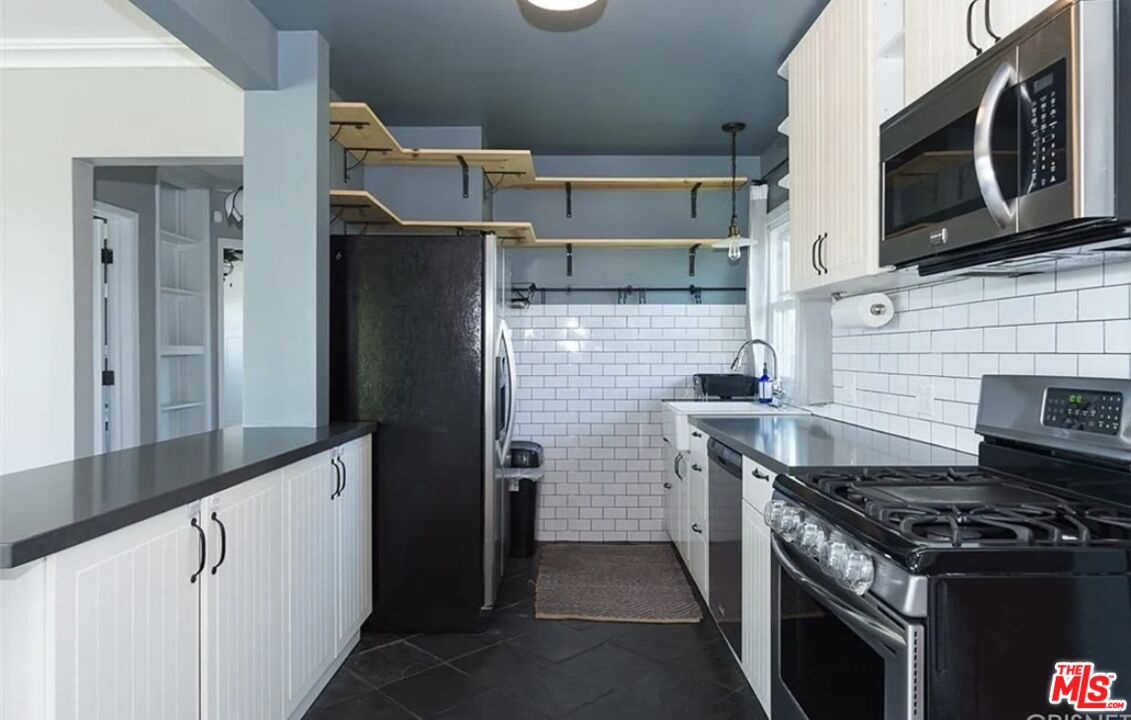 7032 Trask Avenue Playa del Rey, CA 90293 - Photo 9 of 35 a kitchen with stainless steel appliances granite countertop a stove and a microwave