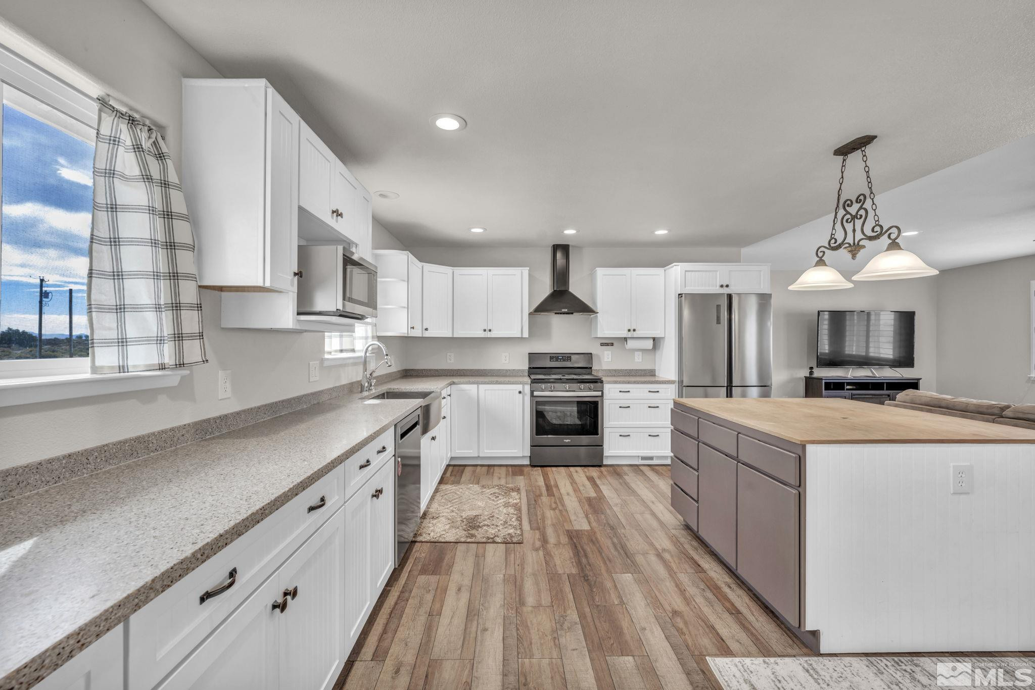 7330 Sandhill Road Fallon, NV 89406 - Photo 10 of 39 a large kitchen with stainless steel appliances granite countertop a stove oven and a white cabinets with wooden floor