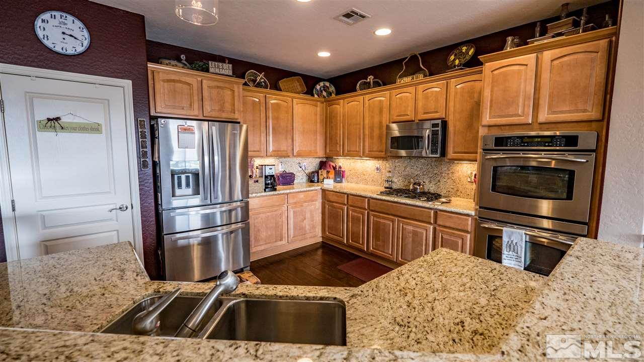 1295 Tarleton Way Reno, NV 89523 - Photo 7 of 23 a kitchen with granite countertop a refrigerator and a stove top oven
