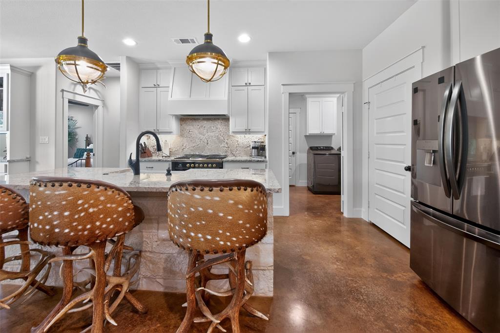 6371 Mill Run Road Athens, TX 75751 - Photo 12 of 40 The kitchen features a large island with a granite countertop and a stainless steel sink with a black gooseneck faucet