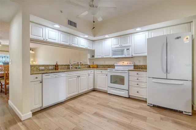 a kitchen with white cabinets and white appliances