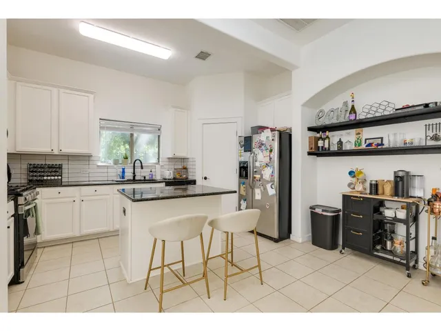 a living room with furniture a flat screen tv and kitchen view