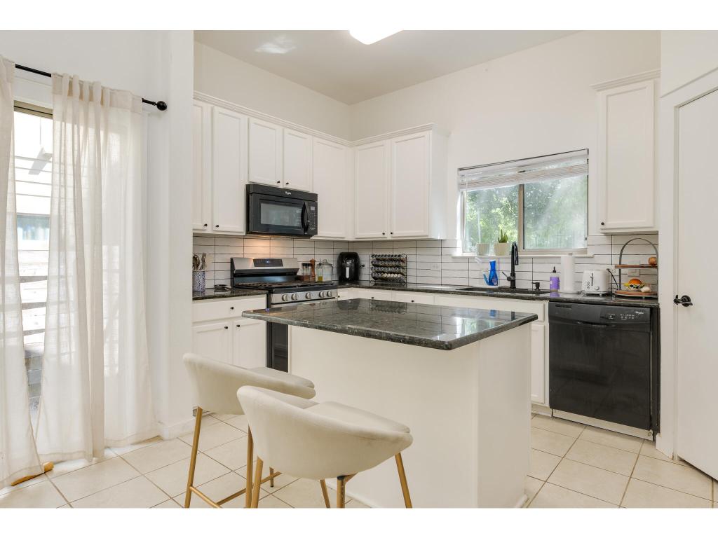 2001 Faro Drive, Unit 53 Austin, TX 78741 - Photo 15 of 34 a kitchen with stainless steel appliances granite countertop a stove a sink and a microwave