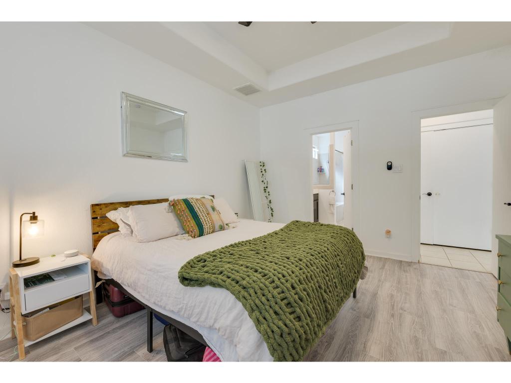 2001 Faro Drive, Unit 53 Austin, TX 78741 - Photo 19 of 34 a bedroom with a bed and a lamp