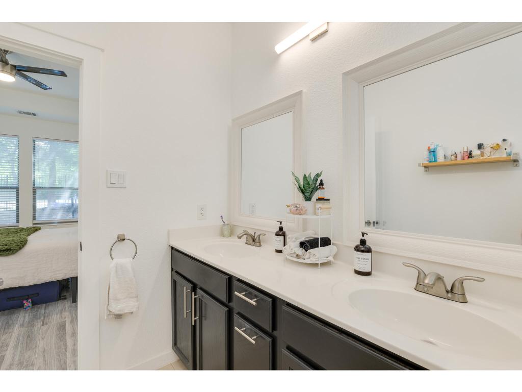 2001 Faro Drive, Unit 53 Austin, TX 78741 - Photo 23 of 34 a bathroom with a double vanity sink and a mirror