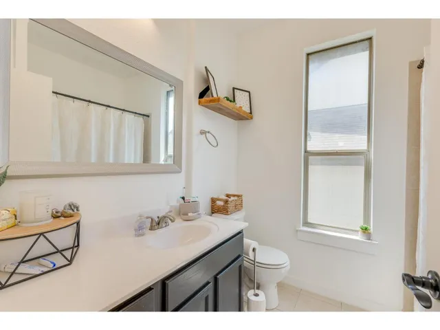a bathroom with a granite countertop sink a toilet and a mirror