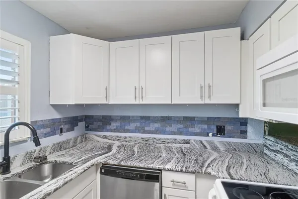 a kitchen with stainless steel appliances granite countertop a sink stove and cabinets