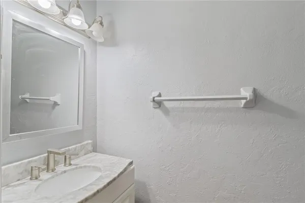a bathroom with a granite countertop sink a mirror and vanity